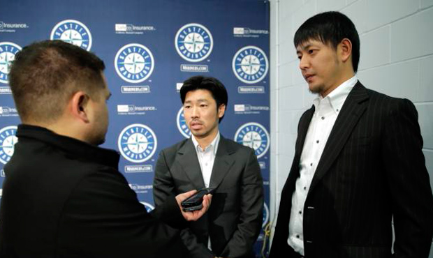 Interpreter Antony Suzuki (l) helps facilitate an interview with Mariners pitcher Hisashi Iwakuma a...