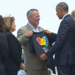 
              President Barack Obama looks at a t-shirt that was presented to him by Orlando, Fla. Mayor Buddy Dyer, center, as Orange County, Fla. Mayor as Teresa Jacobs watches on the tarmac upon his arrival at Orlando International Airport, Thursday, June 16, 2016, in Orlando, Fla. Obama is in Orlando today to pay respects to the victims of the Pulse nightclub shooting and meet with families of victims of the attack. (AP Photo/Pablo Martinez Monsivais)
            