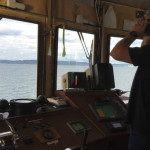 Captain Skip Green looks out from the wheelhouse of the M/V PUGET, searching for snags on Elliott Bay. (Photo by Feliks Banel)