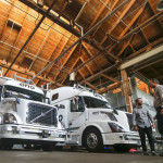 FILE - In this Thursday, Aug. 18, 2016, file photo, employees stand next to self-driving, big-rig trucks during a demonstration at the Otto headquarters, in San Francisco. Uber's self-driving startup Otto developed technology allowing big rigs to drive themselves. After taking millions of factory jobs, robots could be coming for a new class of worker: people who drive for a living. (AP Photo/Tony Avelar, File)