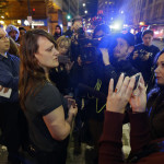 
              Sharon Keith, center-left, who works in a store near where a shooting took place, Wednesday, Nov. 9, 2016, in downtown Seattle, cries as she talks to reporters about the shooting. Authorities say a man escaped on foot after firing into a crowd and wounding five people outside a convenience store in downtown Seattle. (AP Photo/Ted S. Warren)
            