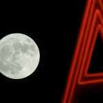 
              The moon rises behind a neon sign in Sacramento, Calif., Sunday, Nov. 13, 2016. Monday morning's supermoon will be the closet a full moon has been to the Earth since Jan. 26, 1948. (AP Photo/Rich Pedroncelli)
            