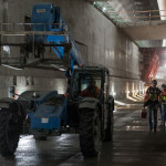 A forklift driver and work crew move through the inside of the SR 99 tunnel. (WSDOT)
