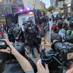 Protester arrested during disbursement order being loaded into SPD can. (Hanna Scott, KIRO Radio)