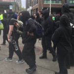 Anarchist marchers begin to gather around Denny Way on May Day 2017. (Mike Lewis, KIRO 7)