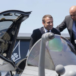 French President Emmanuel Macron exits the cockpit of a Rafale jet fighter helped by Dassault Aviation CEO Eric Trappier, right, while visiting the Paris Air Show in Le Bourget, north of Paris, Monday, June 19, 2017. Macron landed at the Bourget airfield in an Airbus A400-M military transport plane to launch the aviation showcase, where the latest Boeing and Airbus passenger jets will vie for attention with an F-35 warplane, drones and other and high-tech hardware. (AP Photo/Michel Euler)