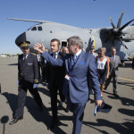 French President Emmanuel Macron, center left, listens to Emeric d'Arcimoles, center right, after exiting an Airbus A400M turboprop transport plane as part of the Paris Air Show in Le Bourget, north of Paris, Monday, June 19, 2017. Macron landed Monday at the Bourget airfield in an Airbus A400-M military transport plane to launch the aviation showcase, where the latest Boeing and Airbus passenger jets will vie for attention with a F-35 warplane, drones and other and high-tech hardware. (AP Photo/Michel Euler, Pool)