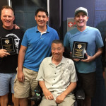 Sgt. Wing Woo presents Ron and Don with plaques of appreciation from his police officers guild, thanking them for their support of cops. (Lauren Padgett, KIRO Radio