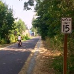 A cyclist rides past a speed limit sign on the Burke-Gilman Trail.
 (Andrew Lanier/KIRO Radio)