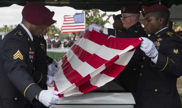 Pallbearers fold the flag draped over the casket of Sgt. La David Johnson during his burial service...