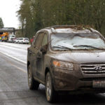 A car covered in mud and debris and with a smashed windshield and other damage sits parked on the shoulder just beyond where an Amtrak train lay spilled onto Interstate 5 below as some train cars remain on the tracks above Monday, Dec. 18, 2017, in DuPont, Wash. The Amtrak train making the first-ever run along a faster new route hurtled off the overpass Monday near Tacoma and spilled some of its cars onto the highway below, killing some people, authorities said. Seventy-eight passengers and five crew members were aboard when the train moving at more than 80 mph derailed about 40 miles south of Seattle before 8 a.m., Amtrak said. (AP Photo/Elaine Thompson)