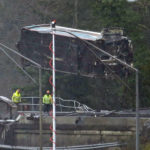 
              A damaged Amtrak train car is lowered from an overpass at the scene of a train crash onto Interstate 5 a day earlier, Tuesday, Dec. 19, 2017, in DuPont, Wash. Federal investigators say they don't yet know why the Amtrak train was traveling 50 mph over the speed limit when it derailed Monday south of Seattle.  (AP Photo/Elaine Thompson)
            