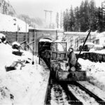 Snow on the ground outside the West Portal of the Cascade Tunnel through Stevens Pass. (Great Northern Railway Historical Society Collection)