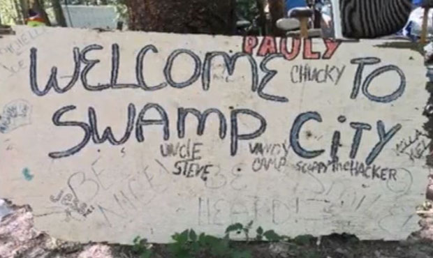 Welcome to Swamp City sign in homeless encampment, homefree...