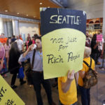 People fill a hallway before a Seattle City Council meeting where the council was expected to vote on a "head tax" Monday, May 14, 2018, in Seattle. The council is to vote on a proposal to tax large businesses such as Amazon and Starbucks to fight homelessness. The plan would tax large businesses about $500 a year per worker to raise about $75 million a year for homeless services and affordable housing. (AP Photo/Elaine Thompson)