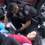 A Seattle police officer begins to disassemble the "sleeping dragon" protesters blocking traffic on Second Avenue the morning of June 5. (KIRO 7)