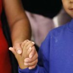 Darwin Micheal Mejia, right, holds hands with his mother, Beata Mariana de Jesus Mejia-Mejia, June 22, 2018, in Linthicum, Md. The Justice Department agreed to release Mejia-Mejia's son after she sued the U.S. government in order to be reunited following their separation at the U.S. border. She has filed for political asylum in the U.S. following a trek from Guatemala. (AP Photo/Patrick Semansky)