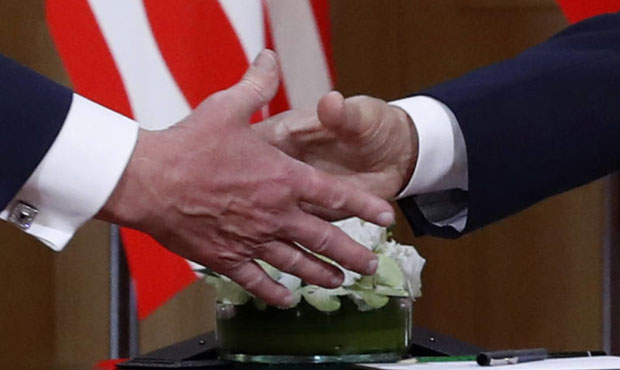 U.S. President Donald Trump, left, and Russian President Vladimir Putin shake hand at the beginning...