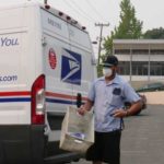 The mail didn't stop while wildfire smoke filled Seattle with a thick, unhealthy haze on August 20, 2018. This mail carrier did use a mask on his route, however. (Matt Pitman, KIRO Radio)
