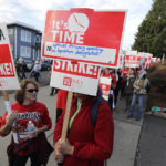 
              A striking teacher carries a picket sign that refers to the Washington State Supreme Court's McCleary decision, which infused $1 billion for teacher pay to districts across the state to resolve the long-running court battle over public education funding, as they march around the Tacoma School District Central Administration Building, Monday, Sept. 10, 2018, in Tacoma, Wash. Teachers in the district have been on strike since last week. (AP Photo/Ted S. Warren)
            