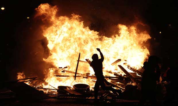 A demonstrator at a burning barricade while protesting with others against the rising of the fuel t...