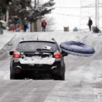    A sledder with an inner tube-type toy hitches a ride back uphill with a driver in an all-wheel drive car heading up one of Seattle's steeper hills, Queen Anne Ave., Monday, Feb. 4, 2019. Western Washington was hit by a major winter storm, with several inches of snow, cold temperatures and bone-chilling winds overnight and into the day Monday. (AP Photo/Elaine Thompson)