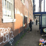 Staff members at Cancer Pathways cover up graffiti on the building.  (Photo by Sophie Rice-Sauer)