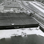 Aerial view of Boeing’s Renton plant in June 1945, taken from north of the plant in the air above Lake Washington; B-29s line the north side of the factory, and are visible in the distance alongside the east side of the runway. (The Boeing Company)