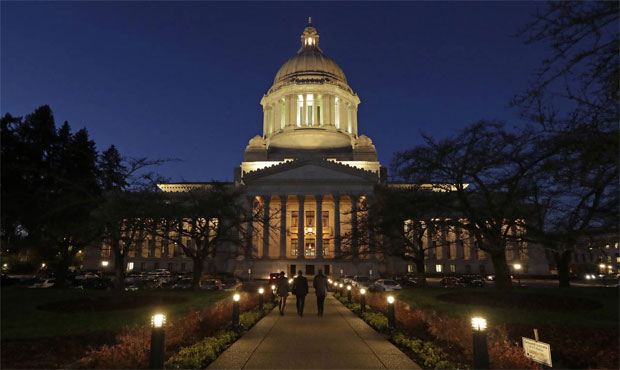 The Washington Capitol illuminated at night, with a lighted walkway leading up to its front pillars. 