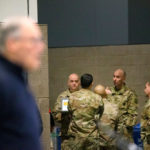 Military personnel talk amongst themselves while Washington State Governor Jay Inslee (L) speaks to the press on March 28, 2020 in Seattle.(Photo by Karen Ducey/Getty Images)