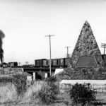 The Battle of Spokane Plains monument as it appeared in 1945, with a Great Northern Railway train passing in the background. (Washington State Historical Society)