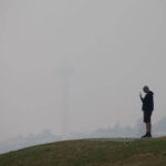 SEATTLE, WA - SEPTEMBER 11:  The Space Needle is almost completely obscured by smoke from wildfires as a man talks on his phone at Gas Works Park on September 11, 2020 in Seattle, Washington. According to reports, air quality is expected to worsen as smoke from dozens of wildfires in forests of the Pacific Northwest and along the West Coast descends onto the region. (Photo by Lindsey Wasson/Getty Images)