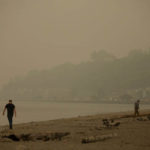 SEATTLE, WA - SEPTEMBER 12:  People walk on the sand as smoke from wildfires fills the air at Alki Beach Park on September 12, 2020 in Seattle, Washington. According to the National Weather Service, the air quality in Seattle remained at "unhealthy" levels Saturday after a large smoke cloud from wildfires on the West Coast settled over the area. (Photo by Lindsey Wasson/Getty Images)