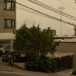 SEATTLE, WA - SEPTEMBER 12:  A man wearing a mask walks up Queen Anne Avenue North as smoke from wildfires fills the air on September 12, 2020 in Seattle, Washington. According to the National Weather Service, the air quality in Seattle remained at "unhealthy" levels Saturday after a large smoke cloud from wildfires on the West Coast settled over the area. (Photo by Lindsey Wasson/Getty Images)