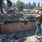 
              Shawn Thornton hugs his wife, Shannon Thornton, next to the rubble of their burned home Tuesday, Sept. 8, 2020, in Malden, Washington the day after a fast-moving wildfire swept through the tiny town west of Rosalia. Shawn and Shannon weren't home at the time, but their son Cody was and managed to get their dog and a few belongings before leaving just minutes before the flames swept through.  (Jesse Tinsley/The Spokesman-Review via AP)
            