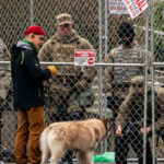 A passerby speaks with National Guardsmen in front of the state Capitol. (Getty Images)