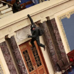 WASHINGTON, DC - JANUARY 06: A protester is seen hanging from the balcony in the Senate Chamber on January 06, 2021 in Washington, DC. Congress held a joint session today to ratify President-elect Joe Biden's 306-232 Electoral College win over President Donald Trump. Pro-Trump protesters have entered the U.S.
 Capitol building after mass demonstrations in the nation's capital. (Photo by Win McNamee/Getty Images)