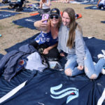 Danielle Losinski and her daughter Cora Lorinski, 13, take a selfie while sitting on a blanket fans got for free at the Seattle Kraken 2021 NHL expansion draft at Gas Works Park on July 21, 2021 in Seattle. (Photo by Karen Ducey/Getty Images)