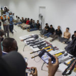 
              FILE - In this July 8, 2021 file photo, suspects in the assassination of Haiti's President Jovenel Moise are shown to the media, along with the weapons and equipment they allegedly used in the attack, at police headquarters in Port-au-Prince, Haiti. Haitian authorities have implicated at least 20 retired Colombian soldiers in the president's assassination on July 7. (AP Photo/Jean Marc Hervé Abélard, File)
            