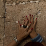 
              A woman prays at the Western Wall, the holiest site where Jews can pray, in the shadow of a wooden pedestrian bridge connecting the wall to the Al Aqsa Mosque compound, in Jerusalem's Old City, Tuesday, July 20, 2021. Experts say the rickety bridge that allows access to the Holy Land's most sensitive religious site is at imminent risk of collapse. But the shrine's delicate position at the epicenter of the Israeli-Palestinian conflict prevents it from being repaired -- raising fears of another disaster just months after 45 people were killed in a stampede at an ultra-Orthodox Jewish shrine where organizers had also ignored years of safety warnings. (AP Photo/Maya Alleruzzo)
            