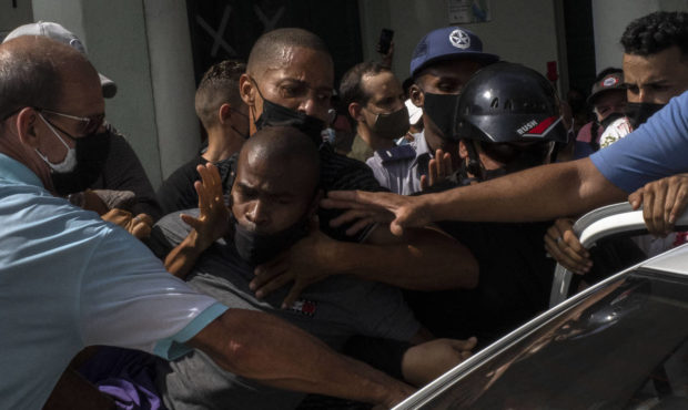 Police detain an anti-government demonstrator during a protest in Havana, Cuba...