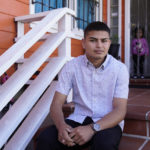 
              Alan Reyes Picado poses outside his home, as his niece looks on from behind, in San Francisco, California, Friday, July 9, 2021. Reyes arrived in the United States in Feb. 2021, after receiving death threats in Nicaragua and is asking for asylum. (AP Photo/Eric Risberg)
            