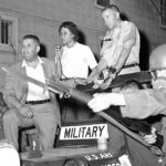 
              FILE - In this May 11, 1964, file photo, masked National Guardsman with their bayonets held at the ready surround the jeep of Brig. Gen. George Gelson, head of the guard unit, as Stanley Branche, chairman of the Committee for Freedom Now, left, and Gloria Richardson, second from left, stands beside him in Cambridge, Md. Richardson, an influential yet largely unsung civil rights pioneer whose determination not to back down while protesting racial inequality was captured in a photograph as she pushed away the bayonet of a National Guardsman, died Thursday, July 15, 2021, in New York, according to Joe Orange, her son in law. She was 99.   (AP Photo/William Smith, File)
            