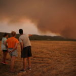 
              Residents look at wildfire near Tarragona, in the northeastern region of Catalonia, Spain, Sunday, July 25, 2021. Firefighters in northeast Spain are battling a wildfire that has consumed over 1,200 hectares (3,000 acres) of woodland. High temperatures and winds fanned the flames in the rural area. (AP Photo/Joan Mateu Parra)
            