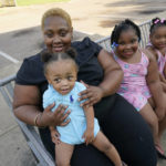 
              Brianne Epps of Jackson, Miss., 28, is a single mother with sons Nolan Epps, 11 months in her arms, Micah Epps, 4, right, and daughters Laila Barnes, 6, second from right, and Kaylee Barnes, 8, center, outside her apartment complex in Jackson, Miss., Wednesday, July 21, 2021. Epps earns $9 an hour working with infants and toddlers in a childcare center, but she has a bigger dream of operating a soul food catering business. (AP Photo/Rogelio V. Solis)
            