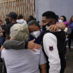 
              FILE - In this July 5, 2021, file photo, Alex Cortillo, right, of Honduras gets a hug from Erika Valladares Ponce, of Honduras, center, and others, as he waits to cross into the United States to begin the asylum process in Tijuana, Mexico. Two nongovernmental organizations said Friday, July 30, 2021, that they are ending cooperation with the Biden Administration to identify the most vulnerable migrants waiting in Mexico to be admitted to the United States to seek asylum. (AP Photo/Gregory Bull, File)
            