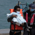 
              A man and a child thought to be migrants are disembarked from a British border force vessel in Dover, south east England, Thursday, July 22, 2021. The number of undocumented migrants reaching Britain in small boats this year has surpassed the total for all of 2020, as people smugglers take advantage of good weather to cross the English Channel from France. (AP Photo/Matt Dunham)
            