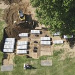 
              In this aerial photo, a mass grave is re-filled with dirt after a small ceremony at Oaklawn Cemetery, Friday, July 30, 2021, in Tulsa, Okla. The mass grave was discovered while searching for victims of the Tulsa Race Massacre. (Mike Simons/Tulsa World via AP)
            