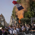 
              A protester waves a French flag during a demonstration in Marseille, southern France, Saturday, Aug. 14, 2021. Thousands of people, from families to far-right sympathizers, marched in dozens of cities across France for a fifth straight Saturday to denounce a COVID-19 health pass needed to access restaurant, long-distance trains and other venues. (AP Photo/Daniel Cole)
            