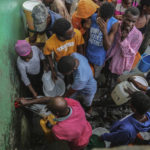 
              People displaced by Saturday´s 7.2 magnitude earthquake collect water after sleeping in the streets in Les Cayes, Haiti, Sunday, Aug. 15, 2021. (AP Photo/Joseph Odelyn)
            